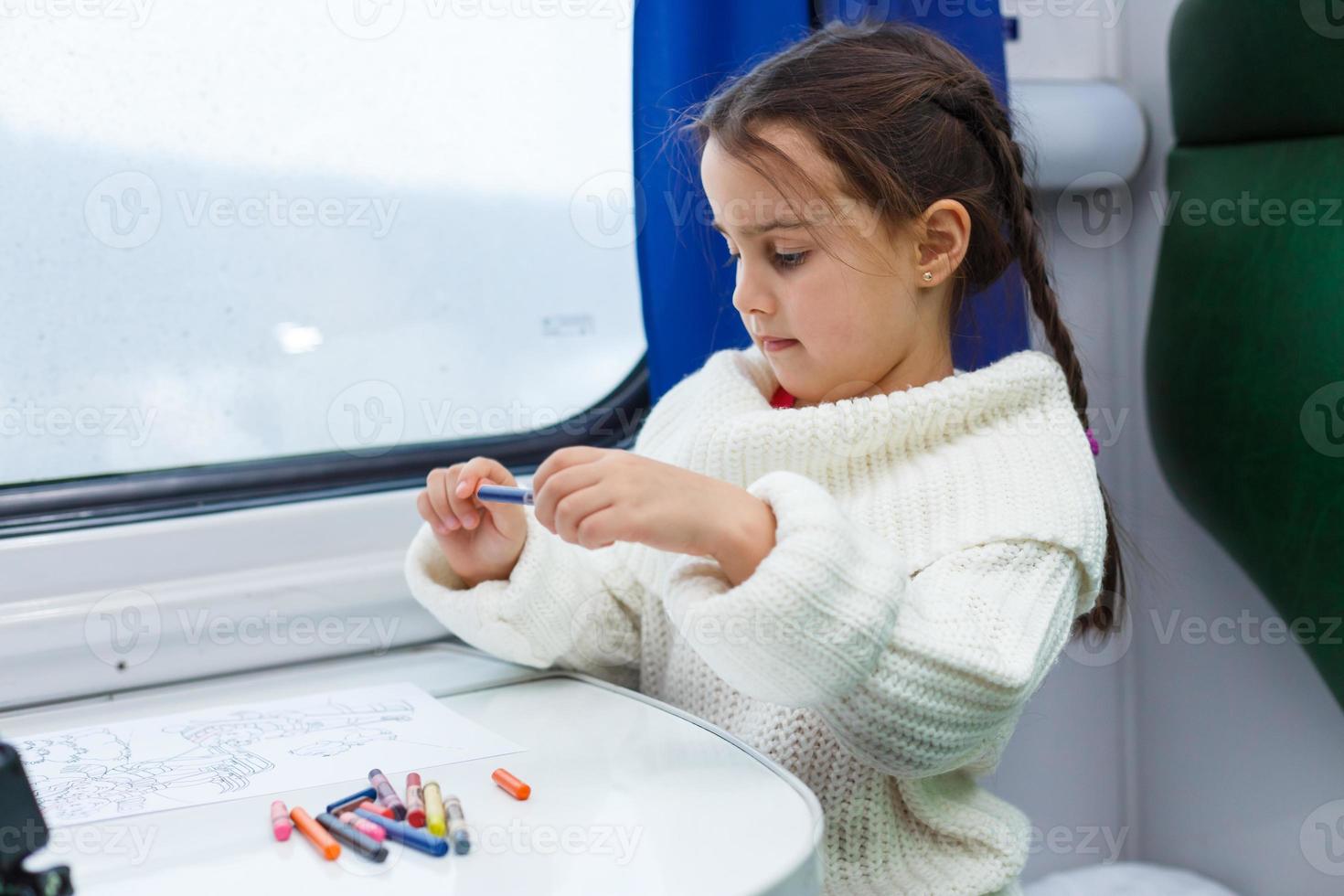 Child traveling by train. Little kid in a high speed express train on family vacation in Europe. Travel by railway. Children in railroad car. Kids in rail way wagon. Entertainment for young passenger. photo