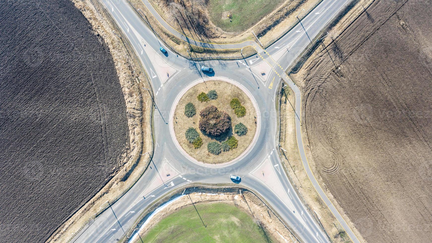 cruce de la rotonda europea de la carretera circular con poco tráfico de automóviles, carril bici y campos agrícolas alrededor. carreteras con rotonda para un mejor transporte foto