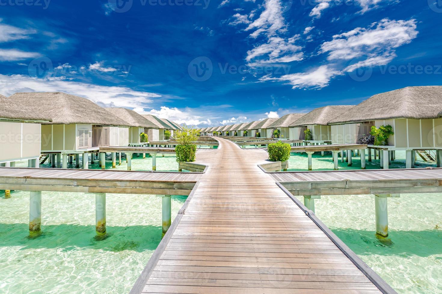 Maldives island beach panorama. Luxury water villas long wooden pier pathway. Tropical vacation and summer holiday background concept. Amazing scenery with copy space photo