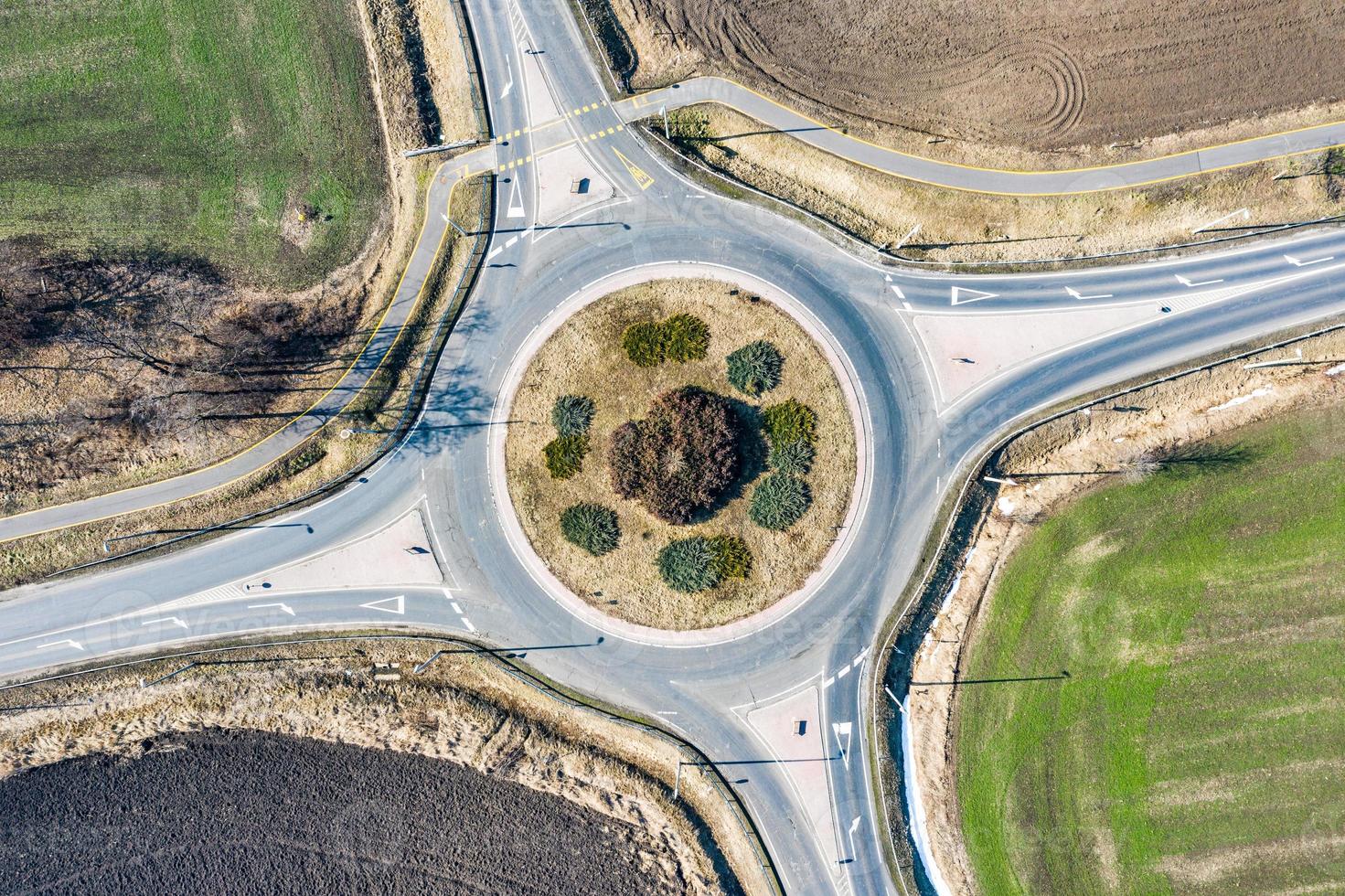 cruce de la rotonda europea de la carretera circular con poco tráfico de automóviles, carril bici y campos agrícolas alrededor. carreteras con rotonda para un mejor transporte foto