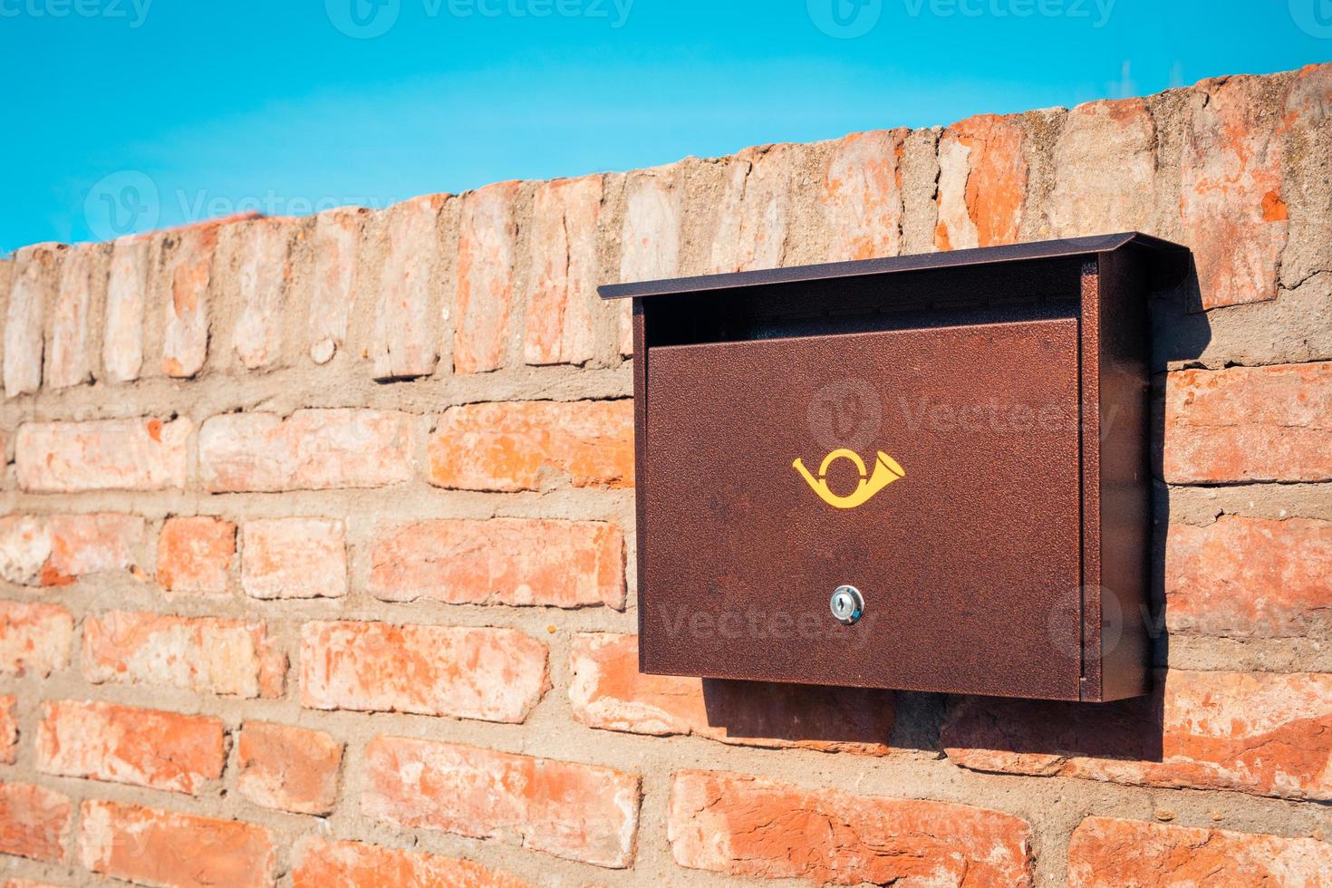 buzón de correo de metal moderno en la pared de piedra de ladrillo foto