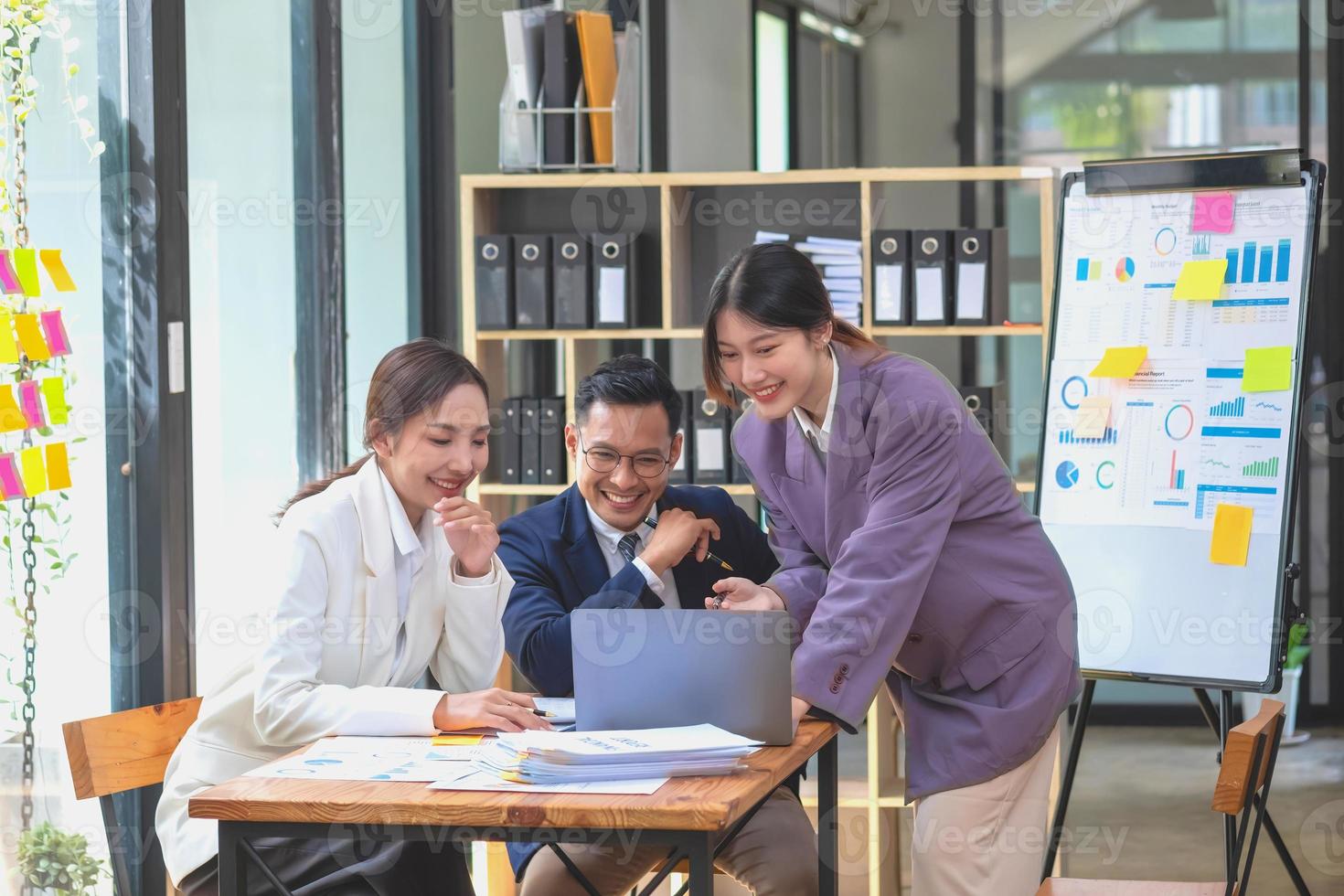 Asian business team consists of marketing staff. accountant and financial officer Help each other analyze company profits using tablets. calculator Laptop computers, graph paper, and corporate pens. photo