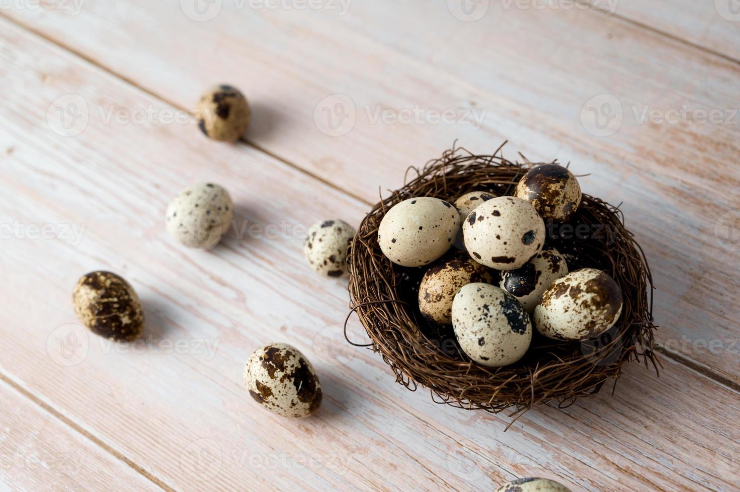Easter banner with quail eggs in the nest on wooden table. Rustic. photo