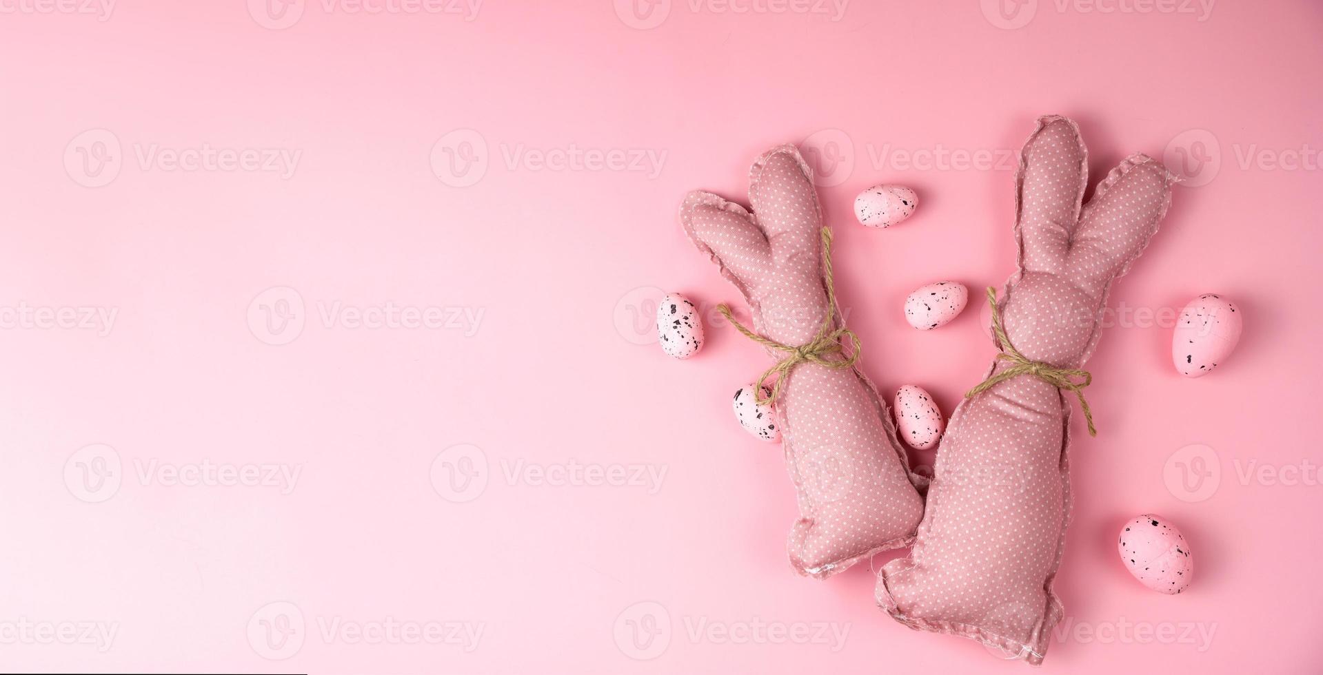 Pink toy bunnies on pink background .Flat lay banner with place for text photo