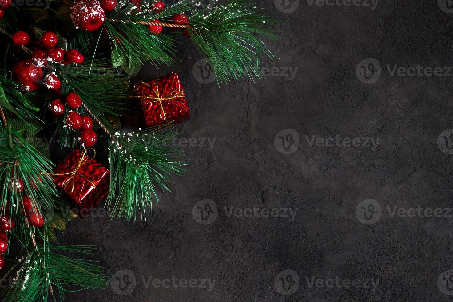 Top view on fir tree branches and gift boxes on dark background. Banner with place for text.Christmas background photo