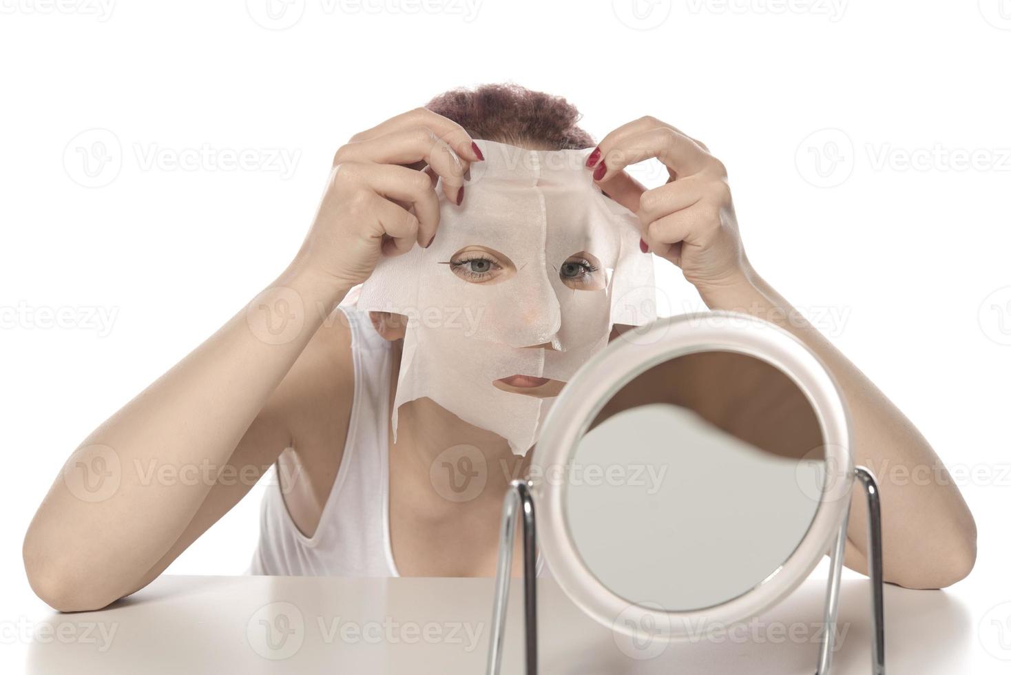 Cosmetic procedure. Woman's face with white cosmetic mask photo