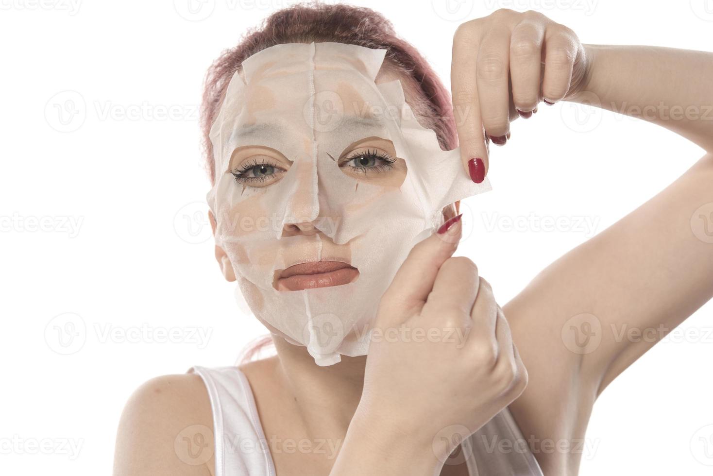 Cosmetic procedure. Woman's face with white cosmetic mask photo