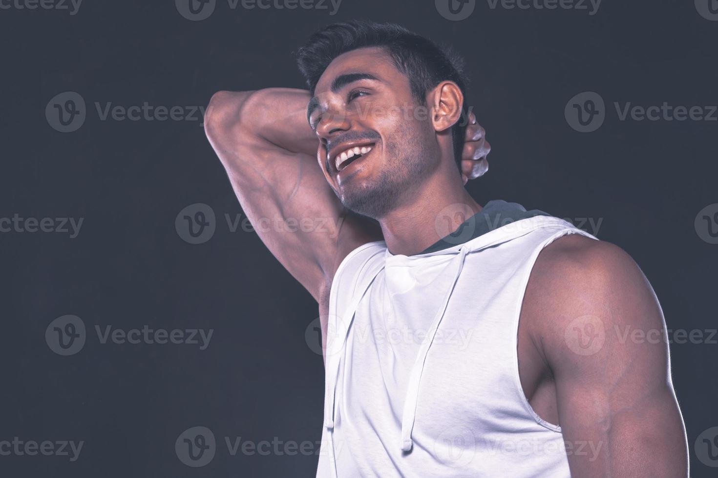 Handsome Arab male model with perfect body posing in studio. Portrait of a athletic male model posing on dark background in the studio. Fashion concept. photo