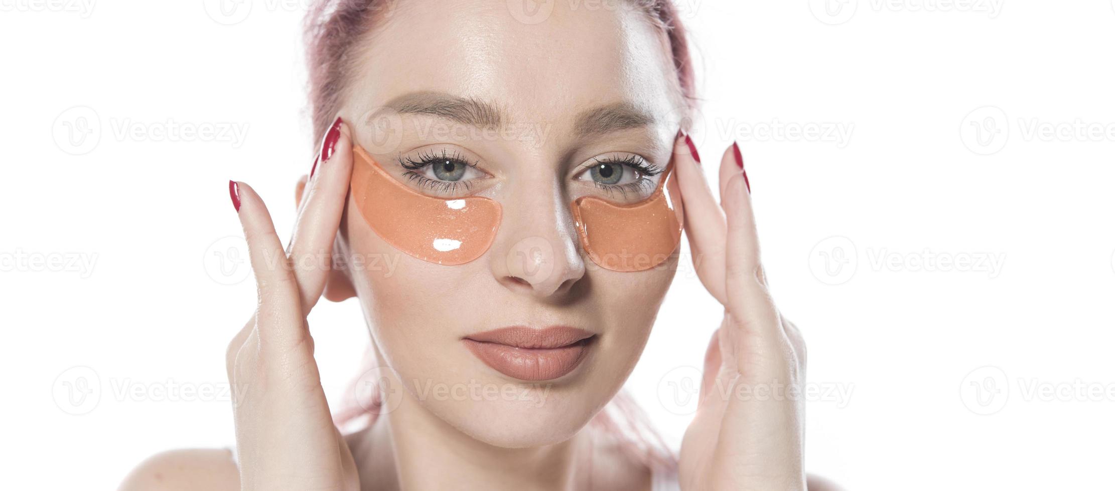 with cosmetic patches moisturizing on skin under eyes. isolated on white background photo