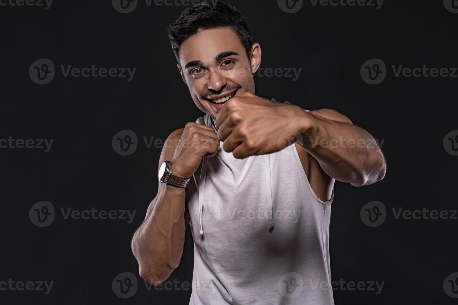 Handsome Arab male model with perfect body posing in studio. Portrait of a athletic male model posing on dark background in the studio. Fashion concept. photo