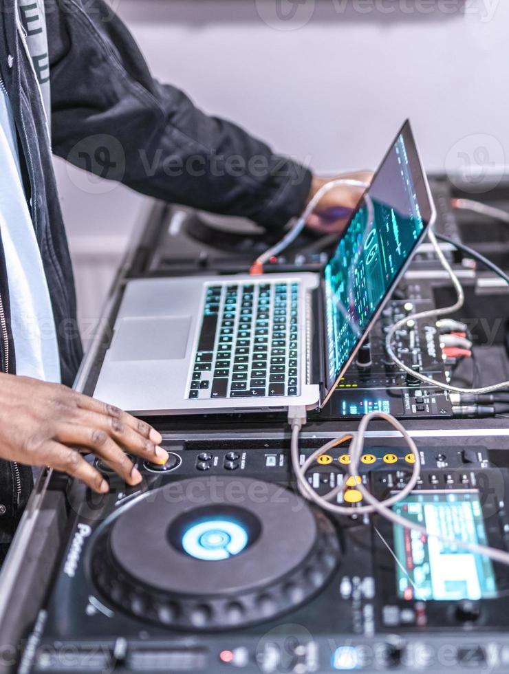 DJ plays live set and mixing music on laptop. Disc Jokey Hands on a laptop at club. photo