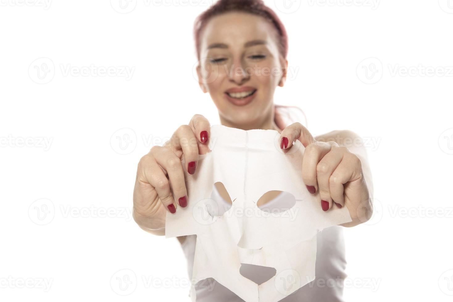 tratamientos faciales y de belleza. mujer con una mascarilla hidratante en la cara aislada de fondo blanco foto