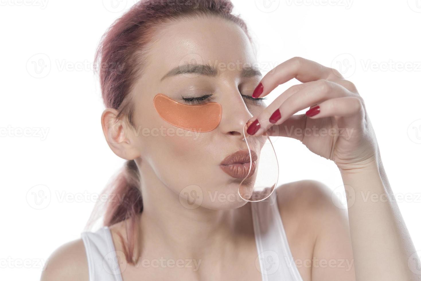 Pretty woman with cosmetic patches moisturizing on skin under eyes. isolated on white background photo