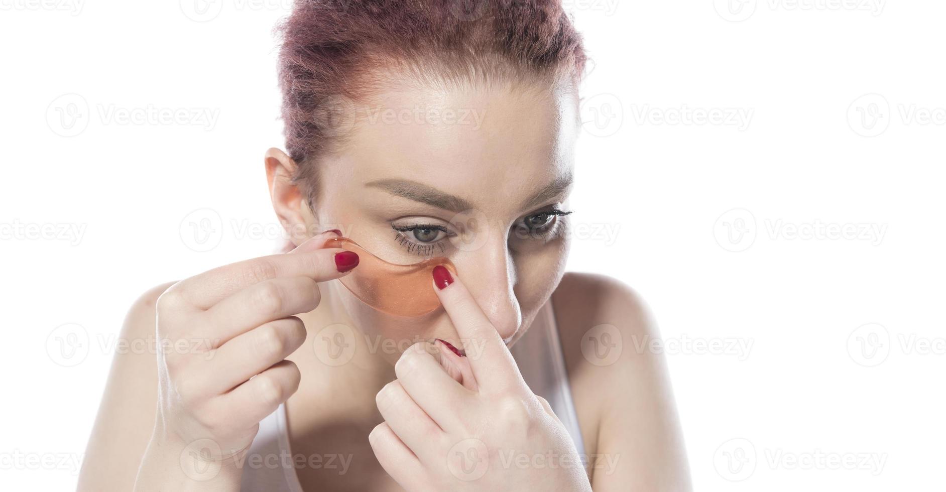 with cosmetic patches moisturizing on skin under eyes. isolated on white background photo