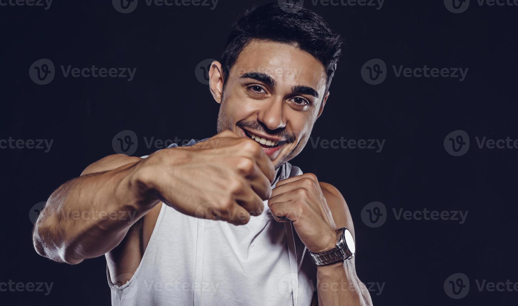 Handsome Arab male model with perfect body posing in studio. Portrait of a athletic male model posing on dark background in the studio. Fashion concept. photo