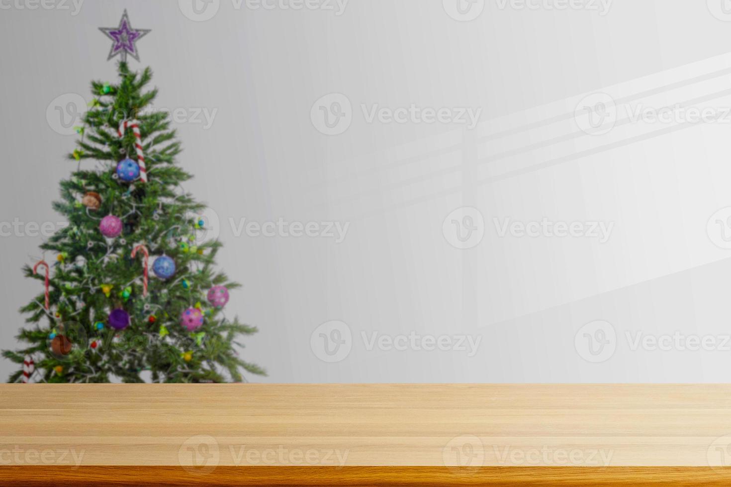 an empty wooden table with a Christmas tree background in the living room photo