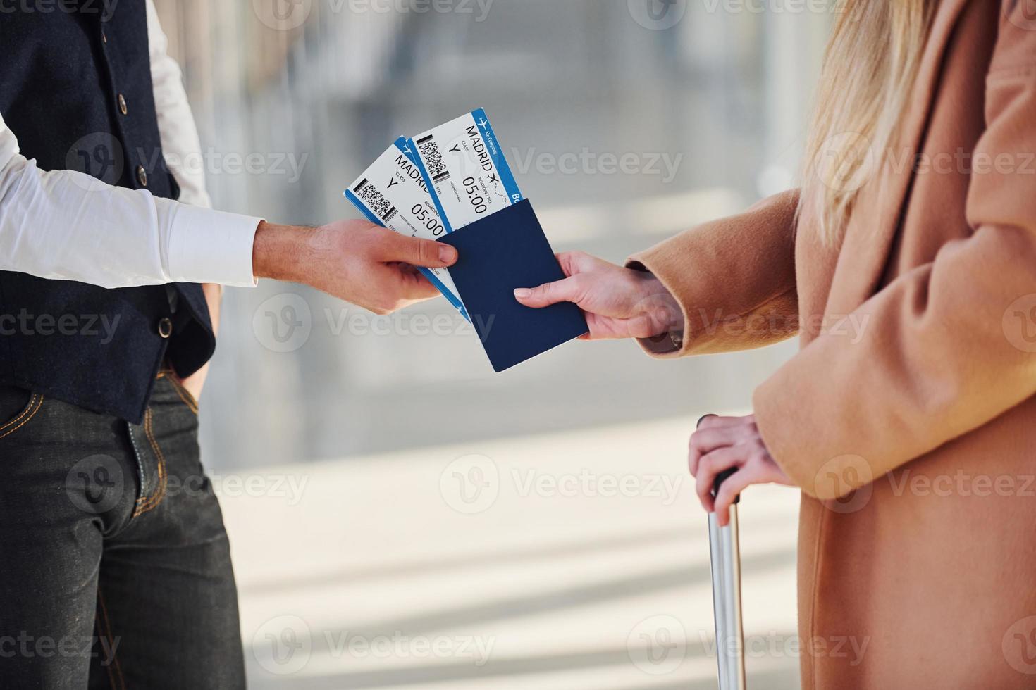 Close up view of woman that gives tickets to security man in airport photo