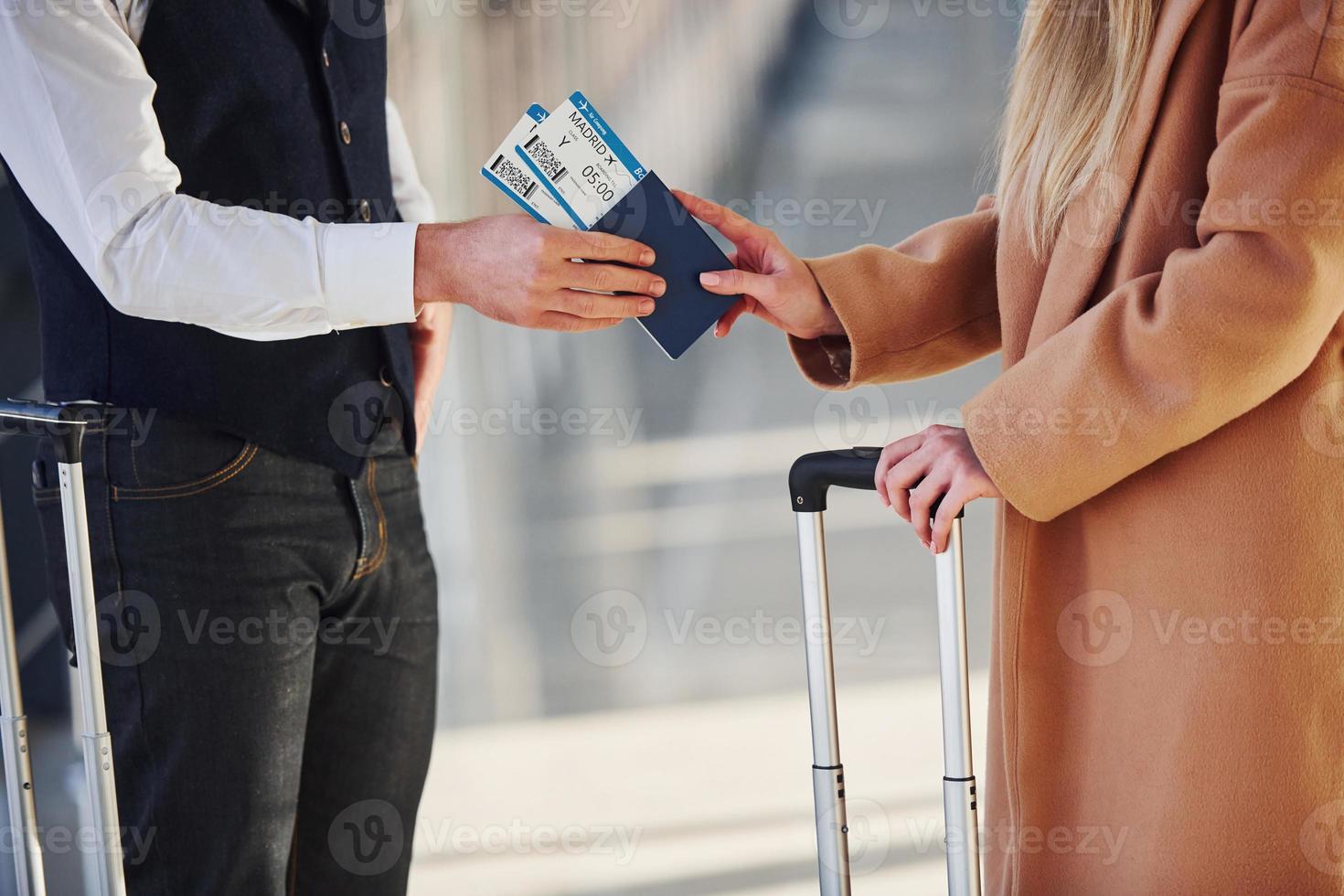 Close up view of woman that gives tickets to security man in airport photo