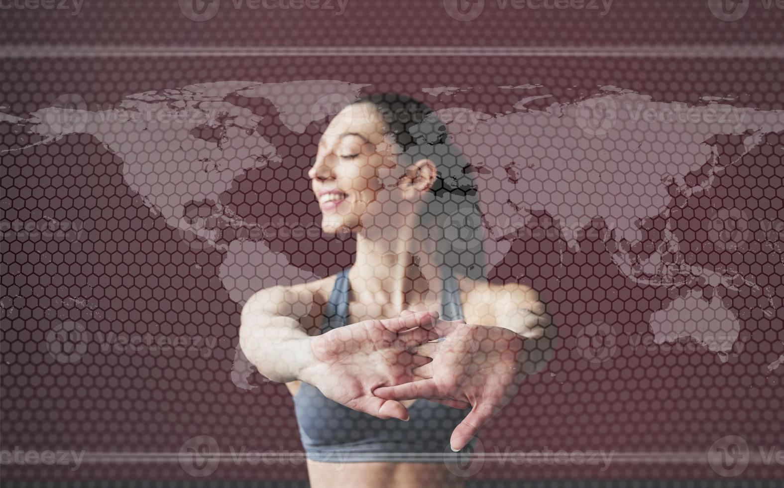 mapa del mundo digital en la imagen. mujer joven con forma de cuerpo delgado en ropa deportiva tiene un día de fitness en el interior foto