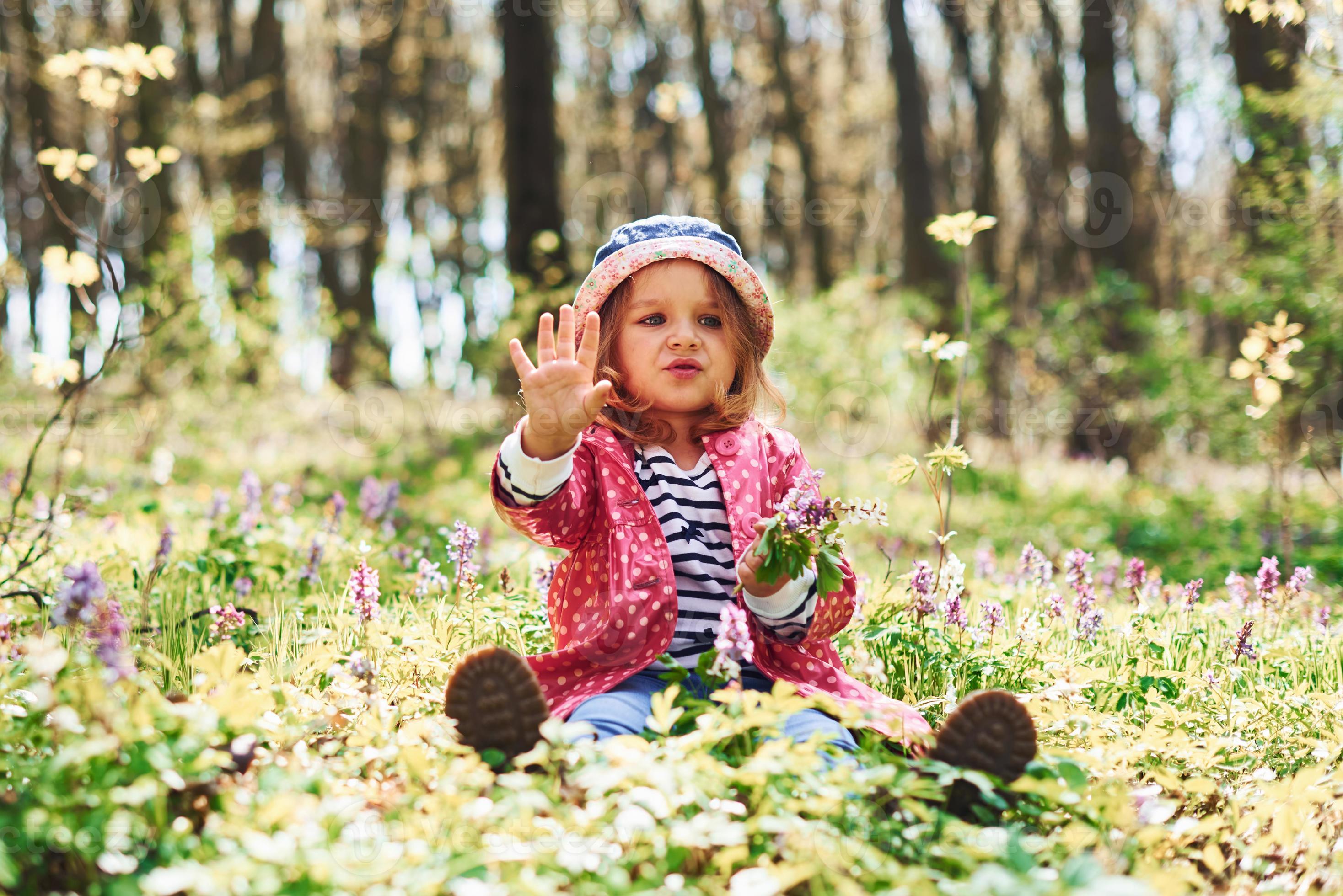 una niña feliz con sombrero azul tiene un paseo por el bosque de primavera  durante el día 15288179 Foto de stock en Vecteezy