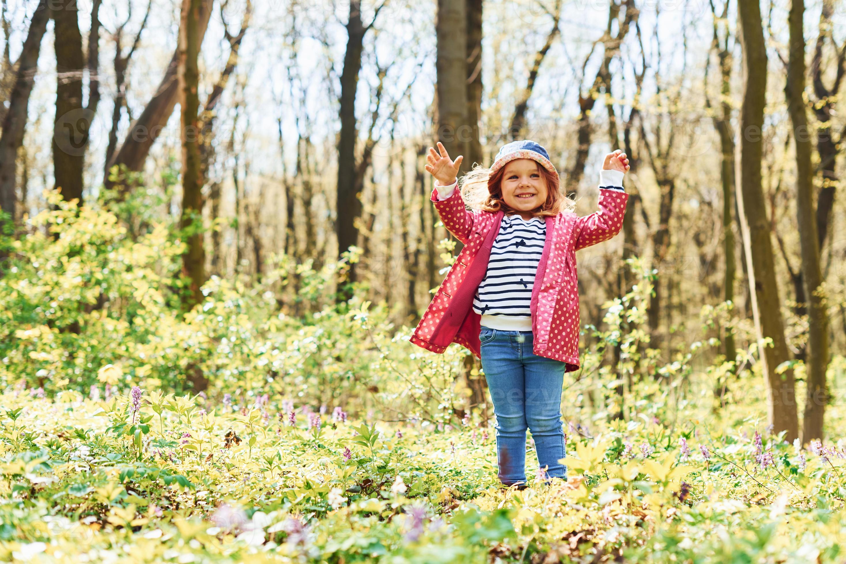 una niña feliz con sombrero azul tiene un paseo por el bosque de primavera  durante el día 15288184 Foto de stock en Vecteezy