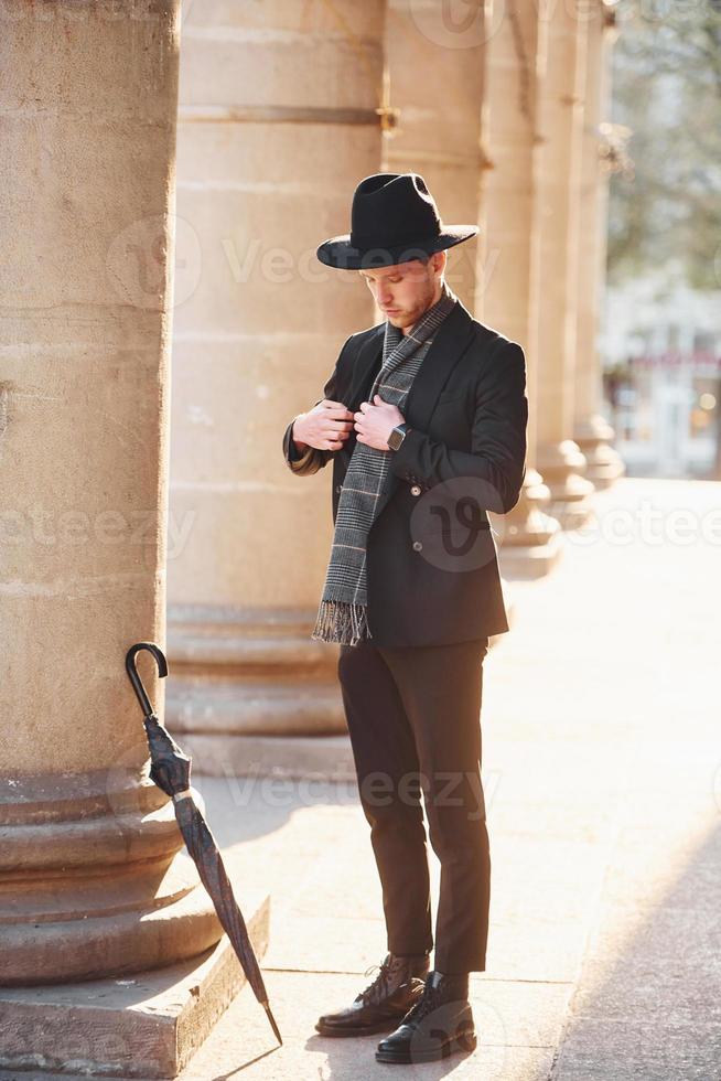 Elegant young man in formal classy clothes outdoors in the city photo