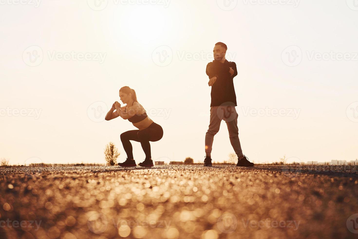 Woman and man have fitness day on the road at evening together photo