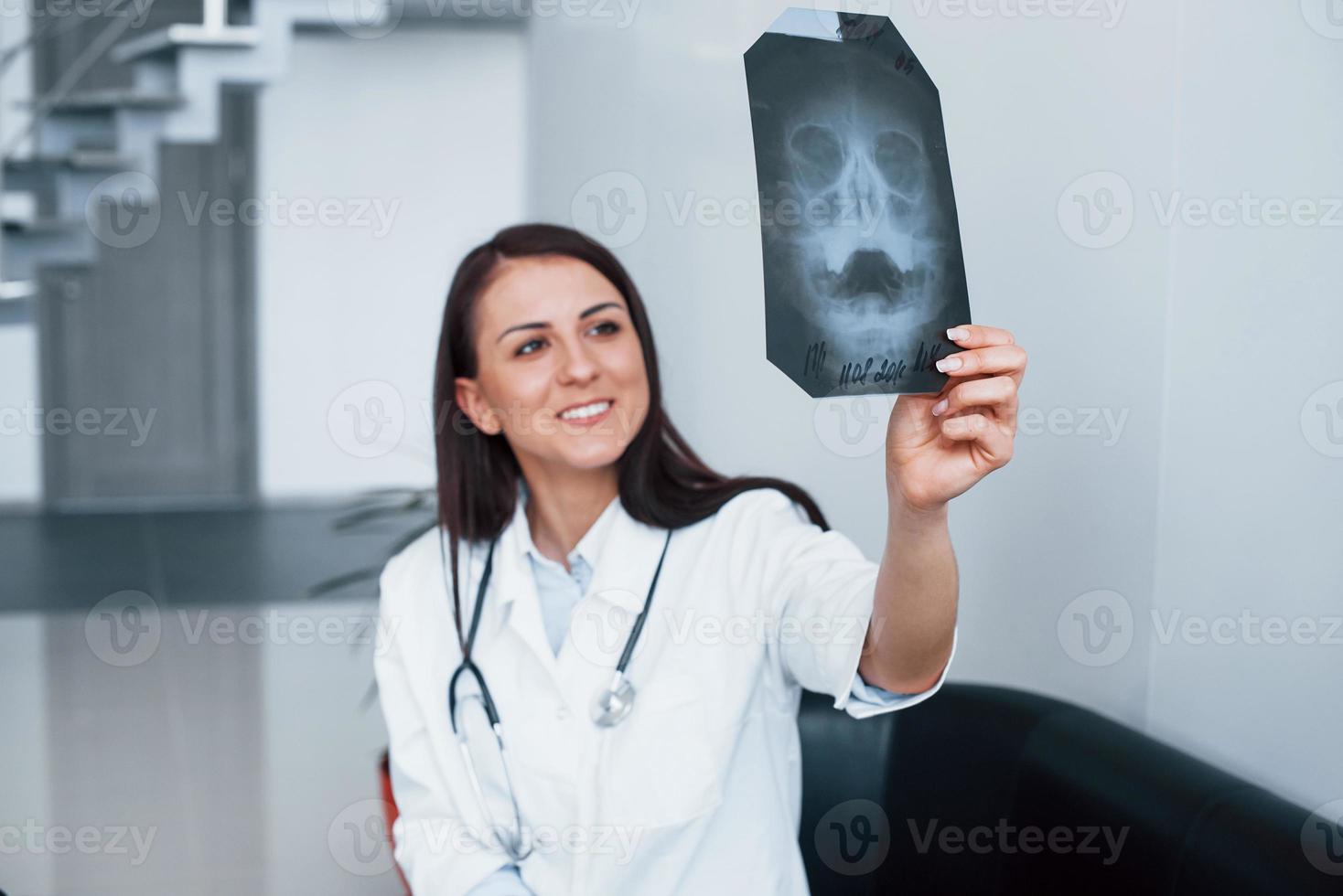 sosteniendo rayos x. joven enfermera en el interior de una clínica moderna. concepción de la salud foto