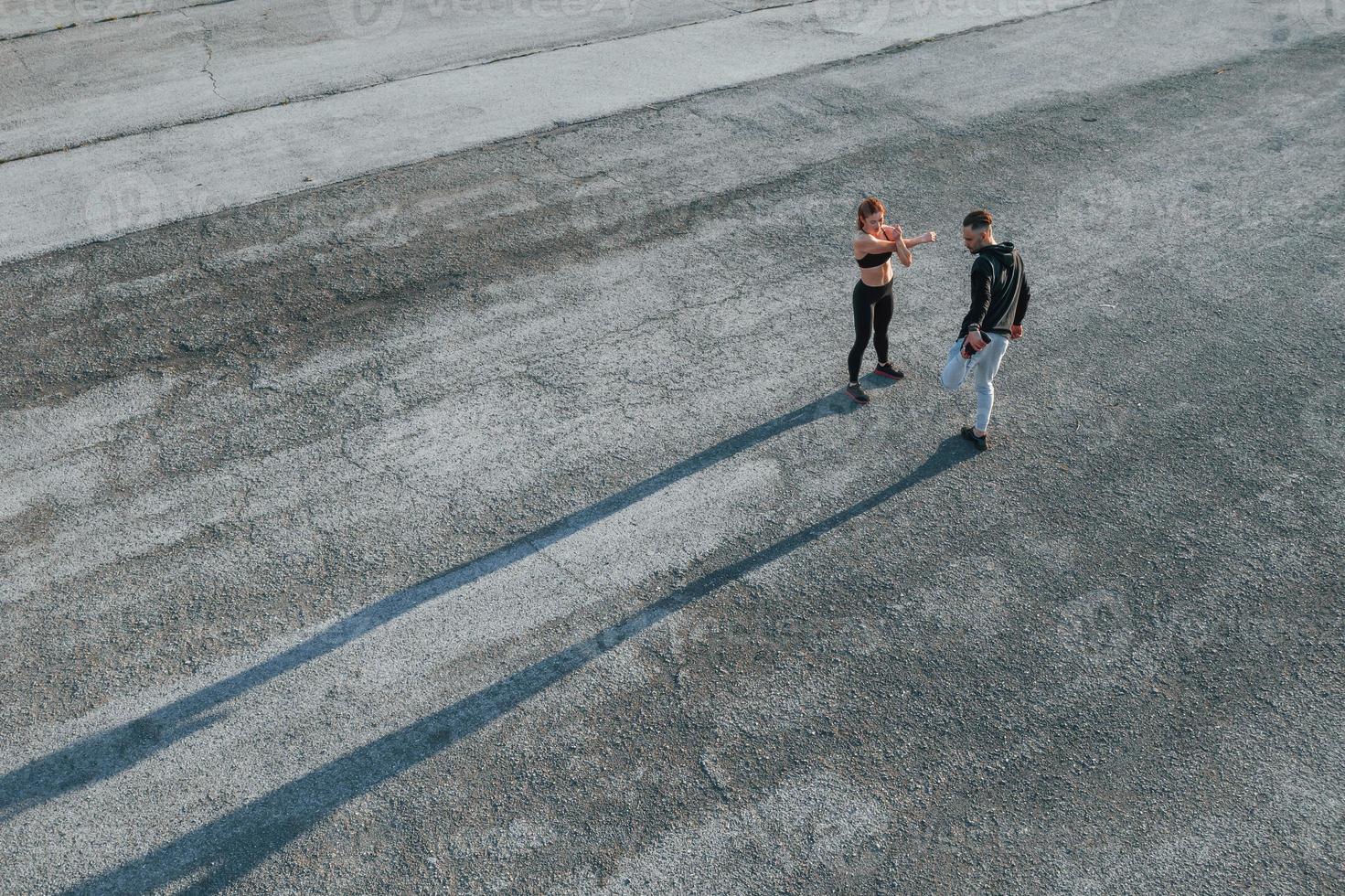 Top view of woman and man that have fitness day on the road at evening together photo