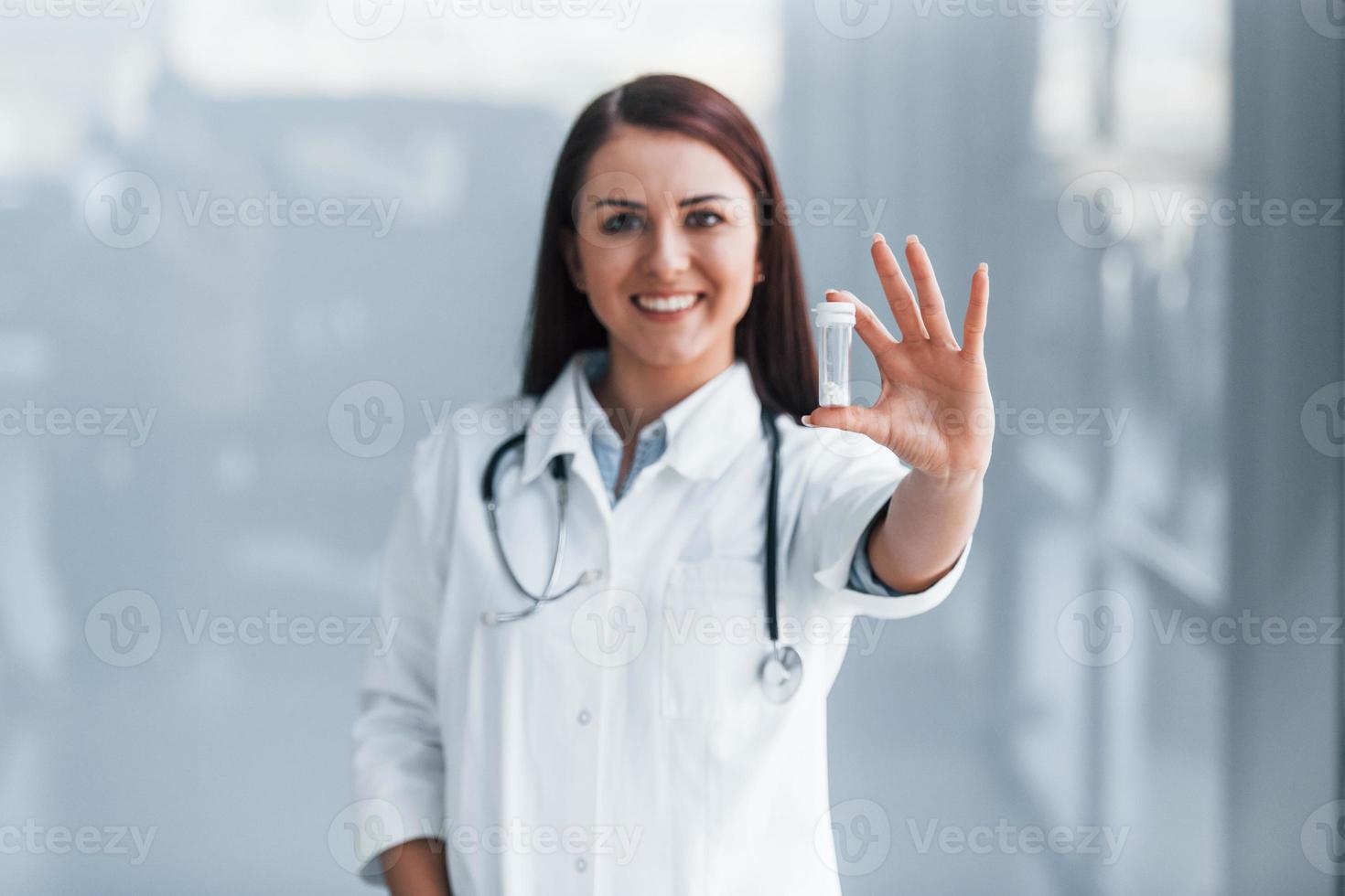Young nurse holding drugs in hands indoors in modern clinic. Conception of healthcare photo