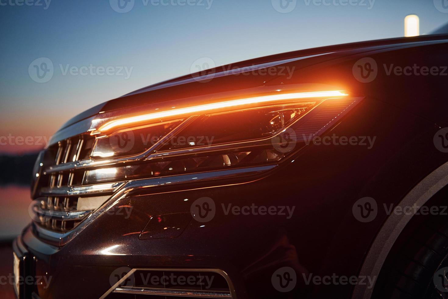 Close up particle view of of front part of modern new car parked outdoors photo