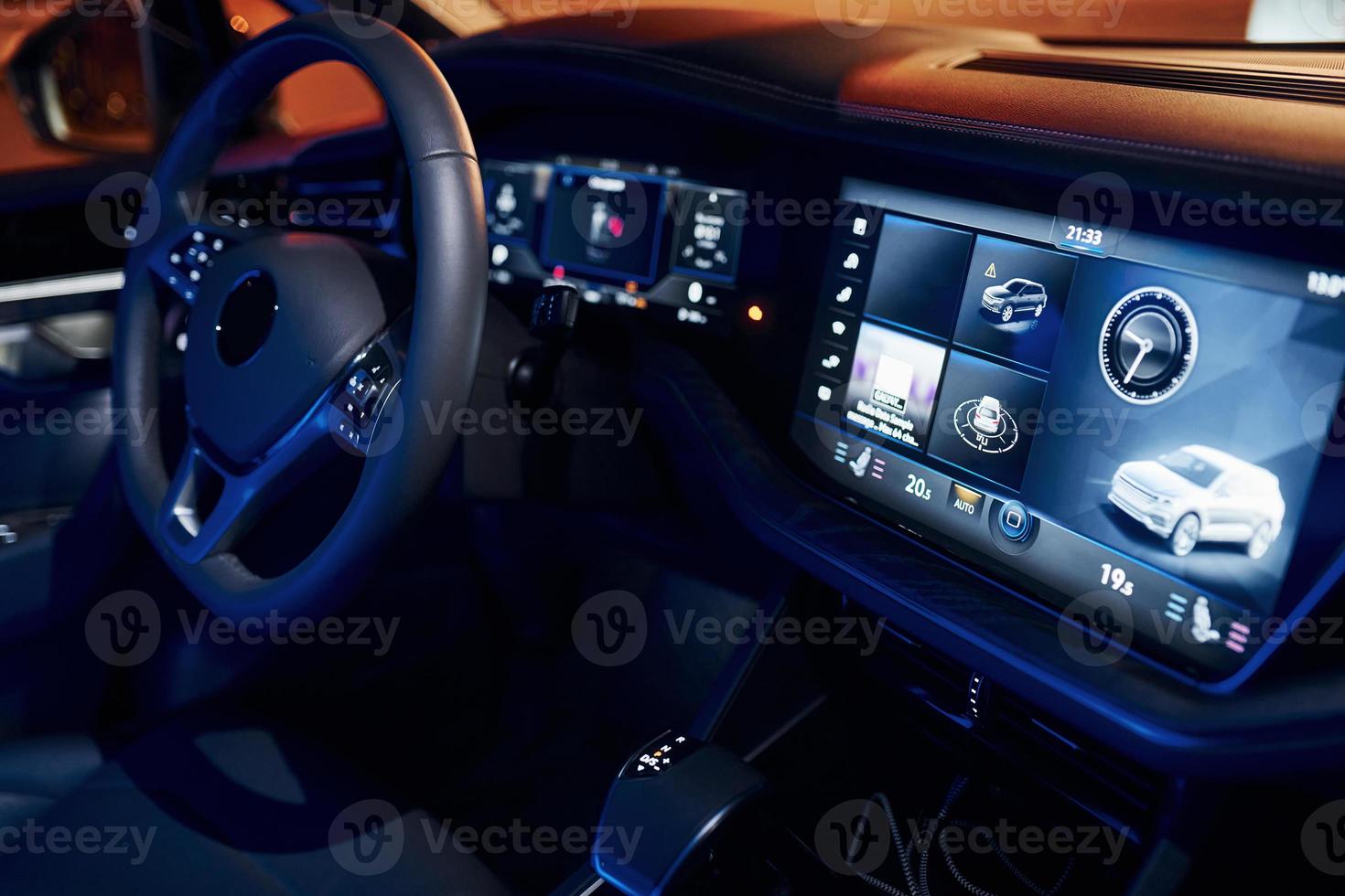 Steering wheel and navigation display. Close up view of front park of new modern black automobile photo