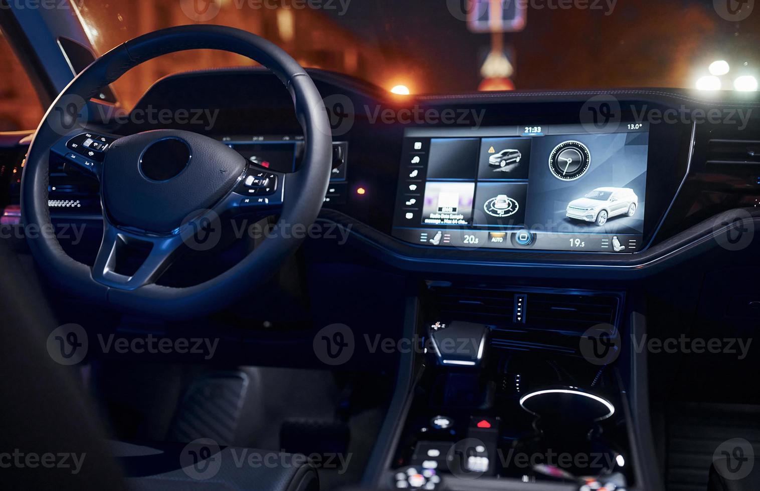 Steering wheel and navigation display. Close up view of front park of new modern black automobile photo