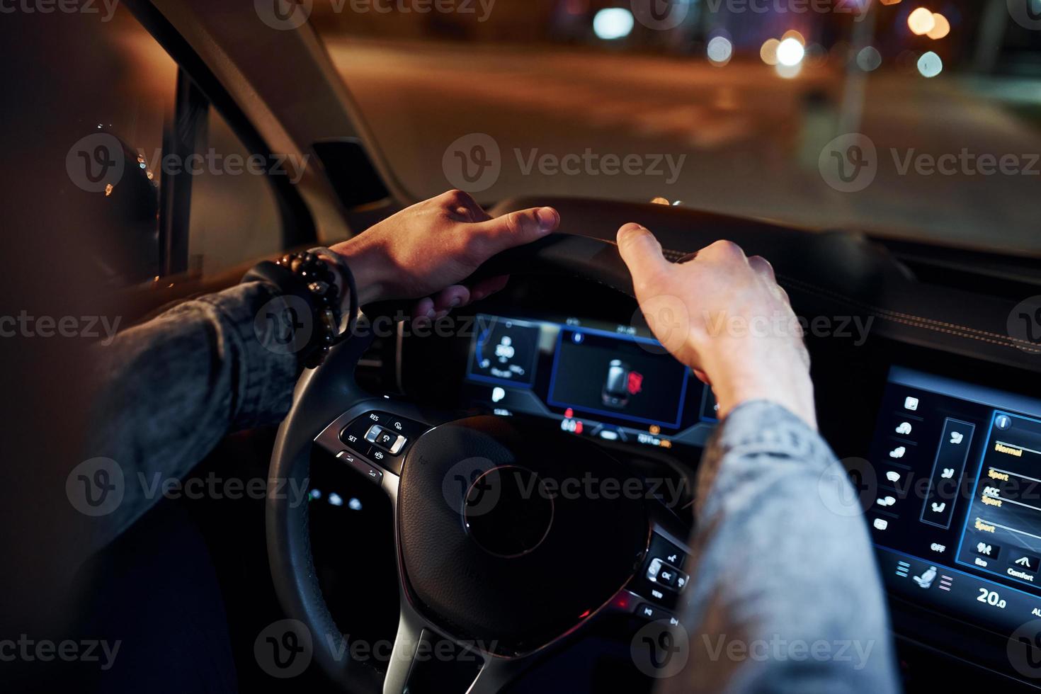 Handsome unshaved man in fashionable clothes riding his automobile photo