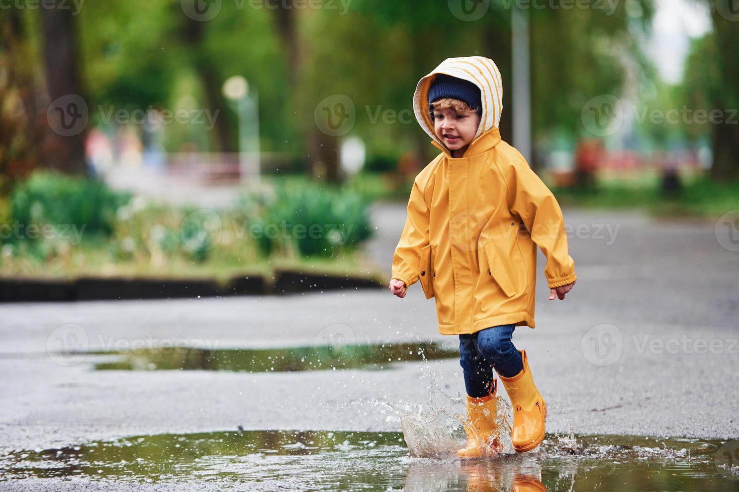 Niño Vestido Con Capa Impermeable Amarilla Y Botas De Goma Parado En Un  Charco Al Aire Libre En La Lluvia En Otoño Imagen de archivo - Imagen de  libertad, lluvia: 198114641