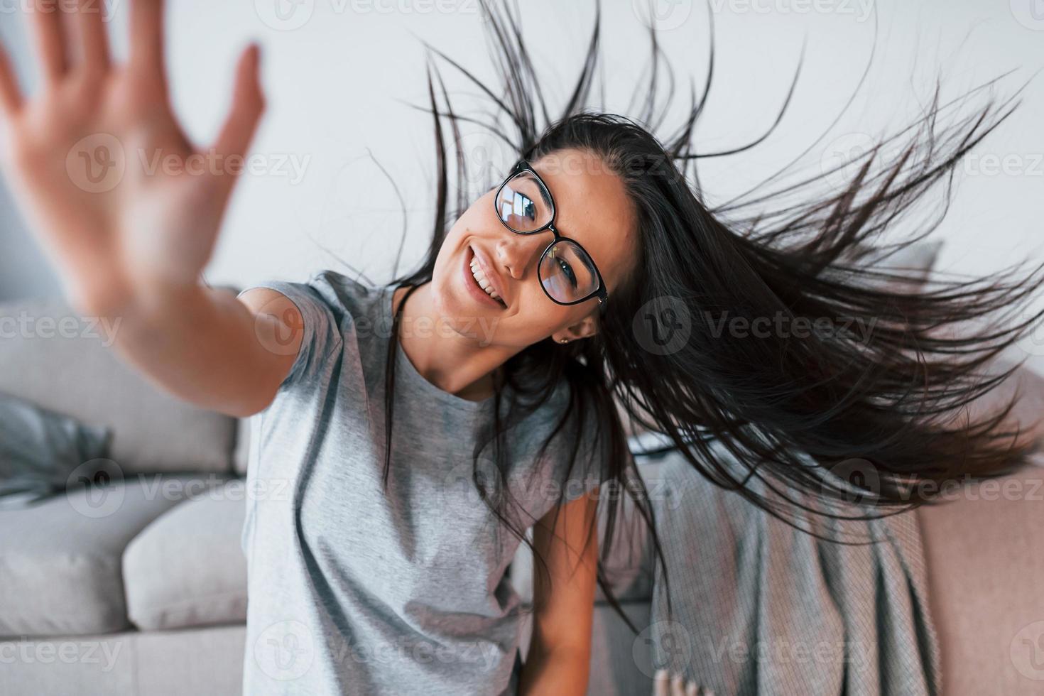 joven hermosa mujer con ropa informal y anteojos se divierte sola en casa foto