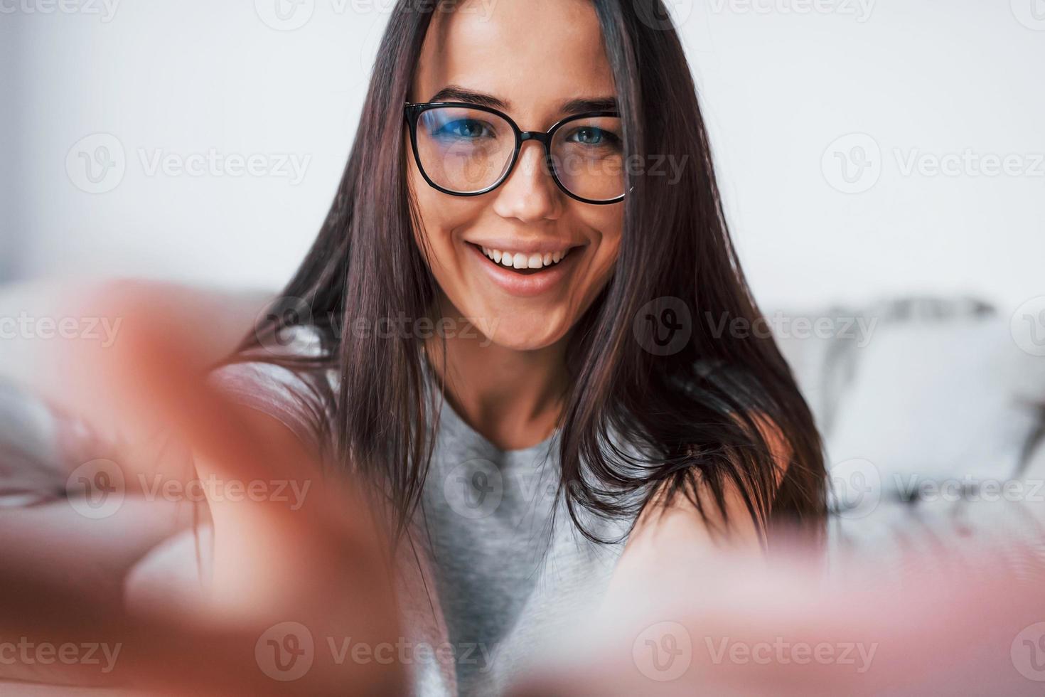 Making selfie. Young beautiful woman in casual clothes and glasses have fun at home alone photo