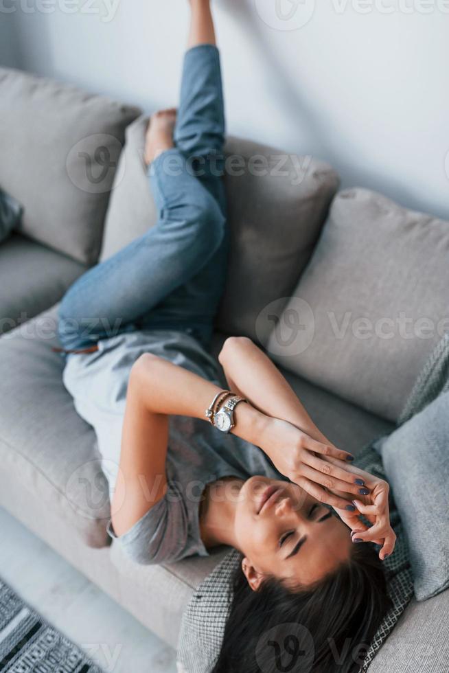 Young beautiful woman in casual clothes lying down at home alone photo