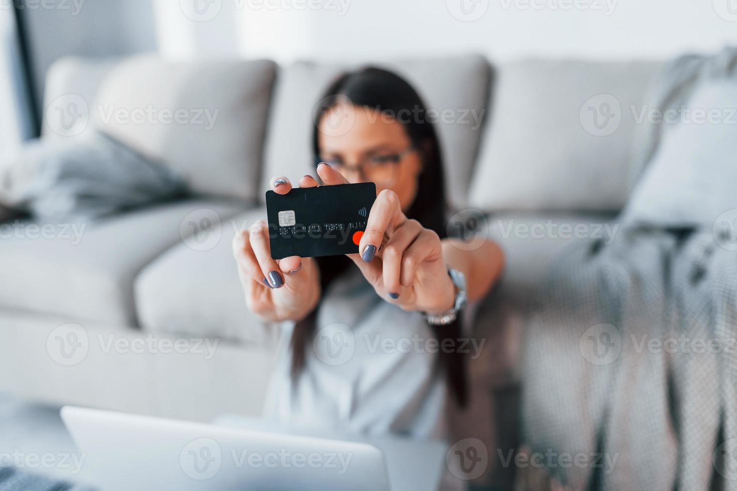 Young beautiful woman in casual clothes holding credit card in hands photo