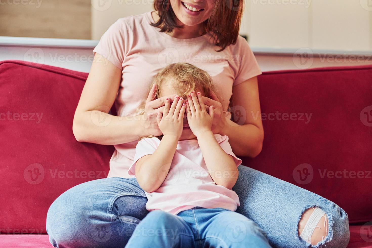 joven madre con su pequeña hija vestida de forma informal juntas en casa foto