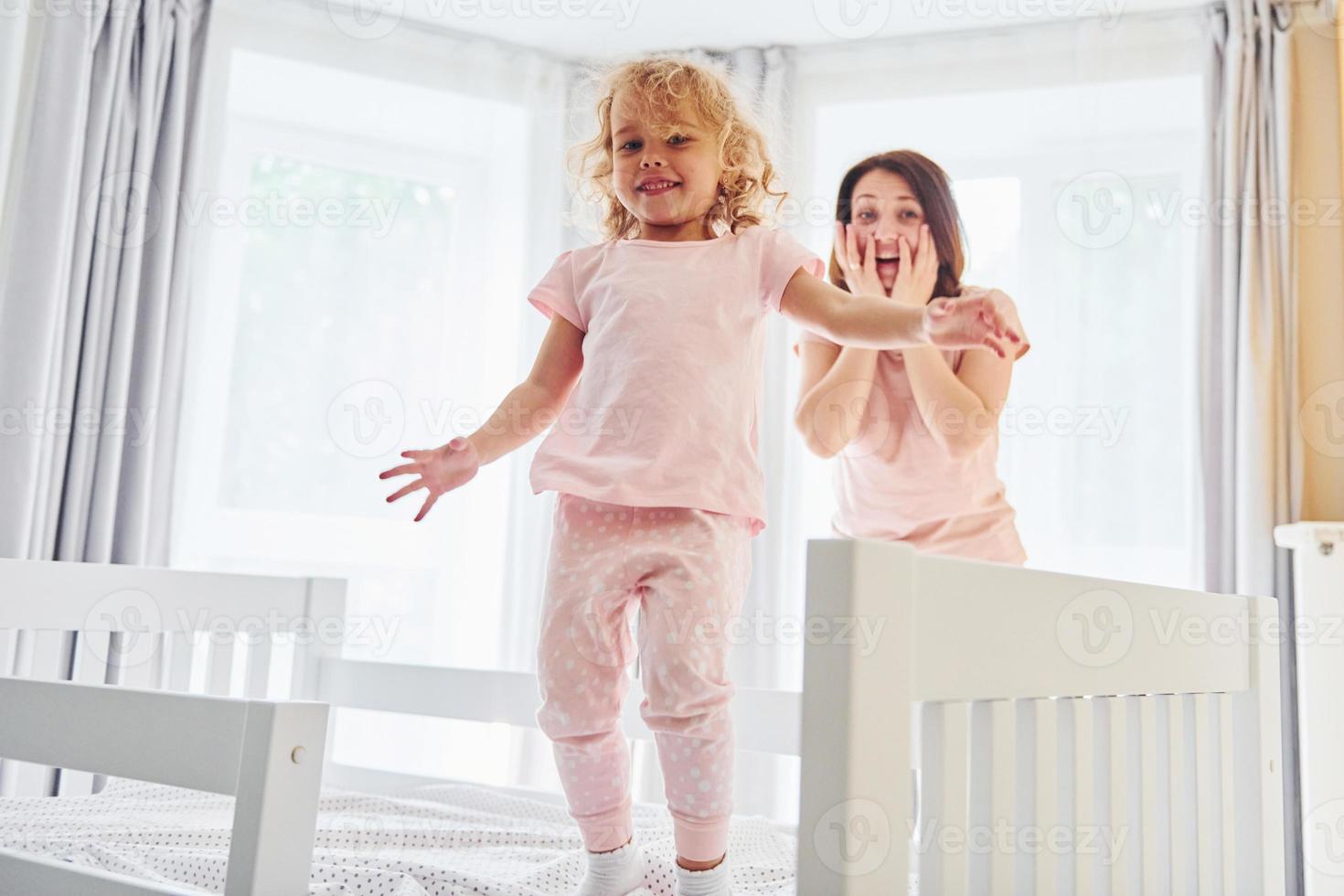 Young mother with her little daughter in casual clothes together indoors at home photo