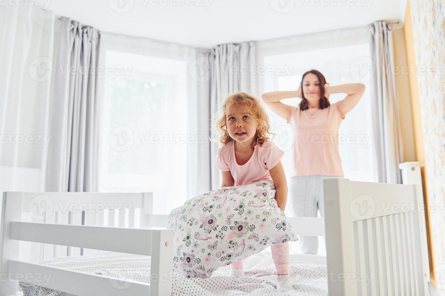 Young mother with her little daughter in casual clothes together indoors at home photo