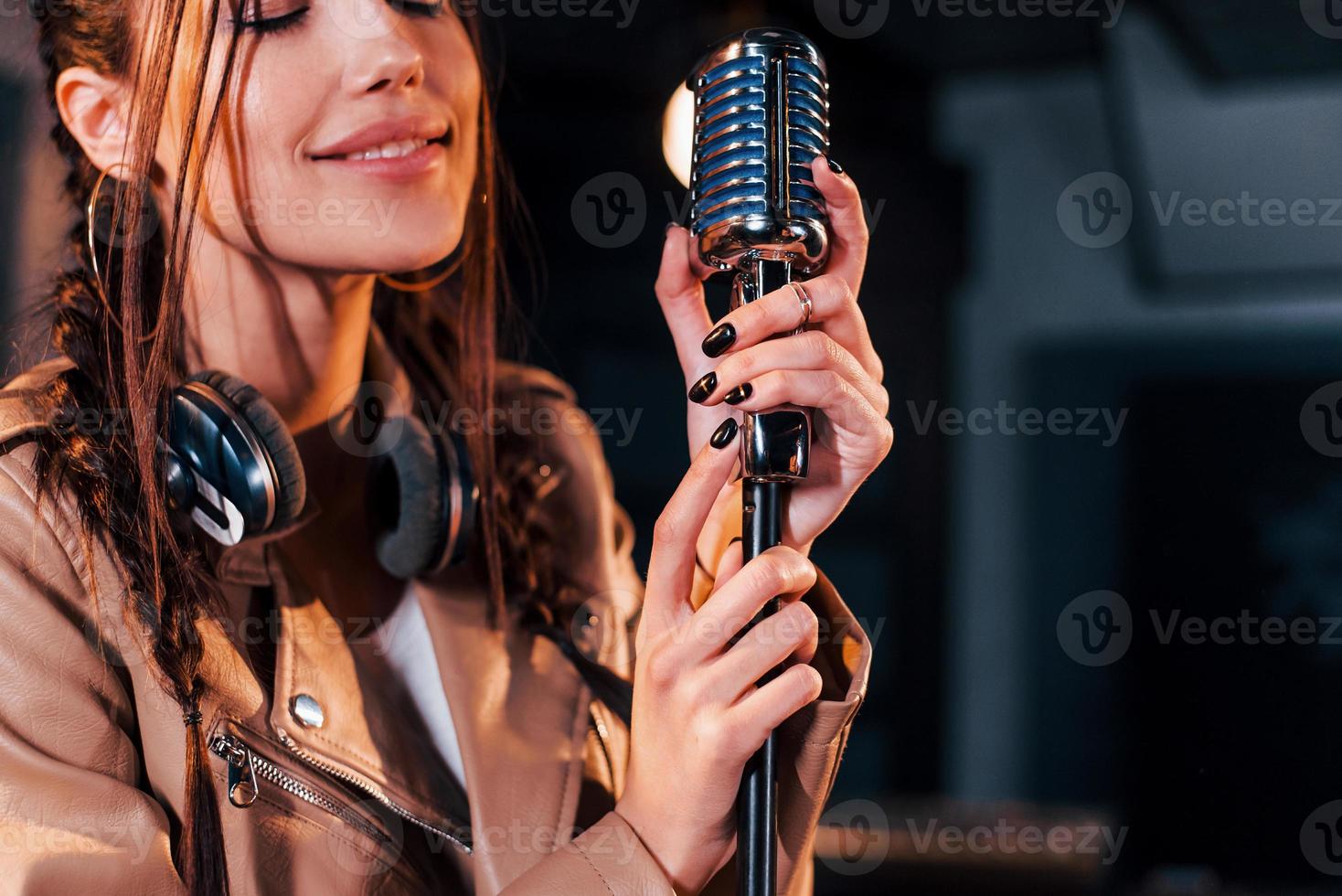 Young beautiful female singer rehearsing in a recording studio 15292986