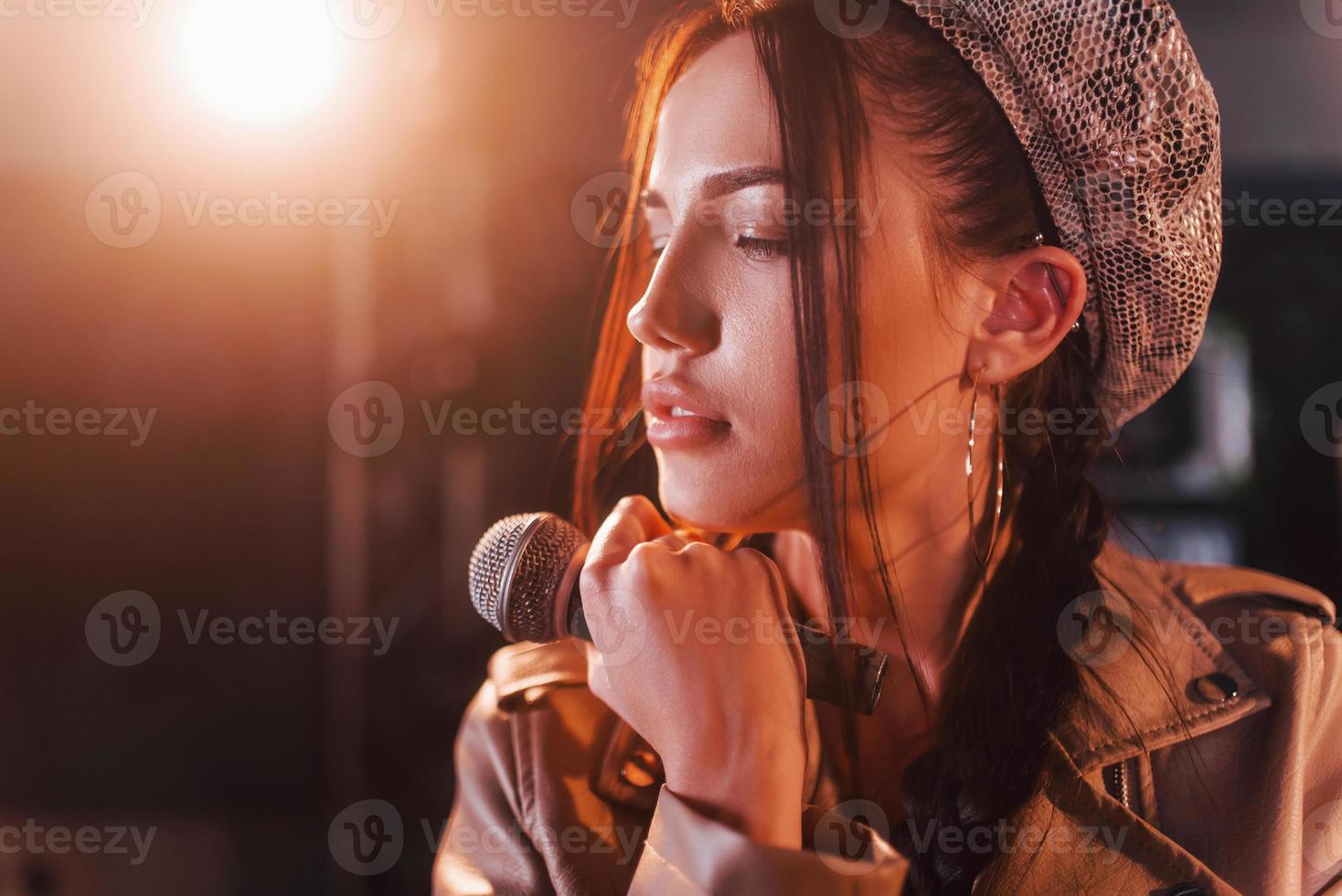 Young beautiful female performer rehearsing in a recording studio photo