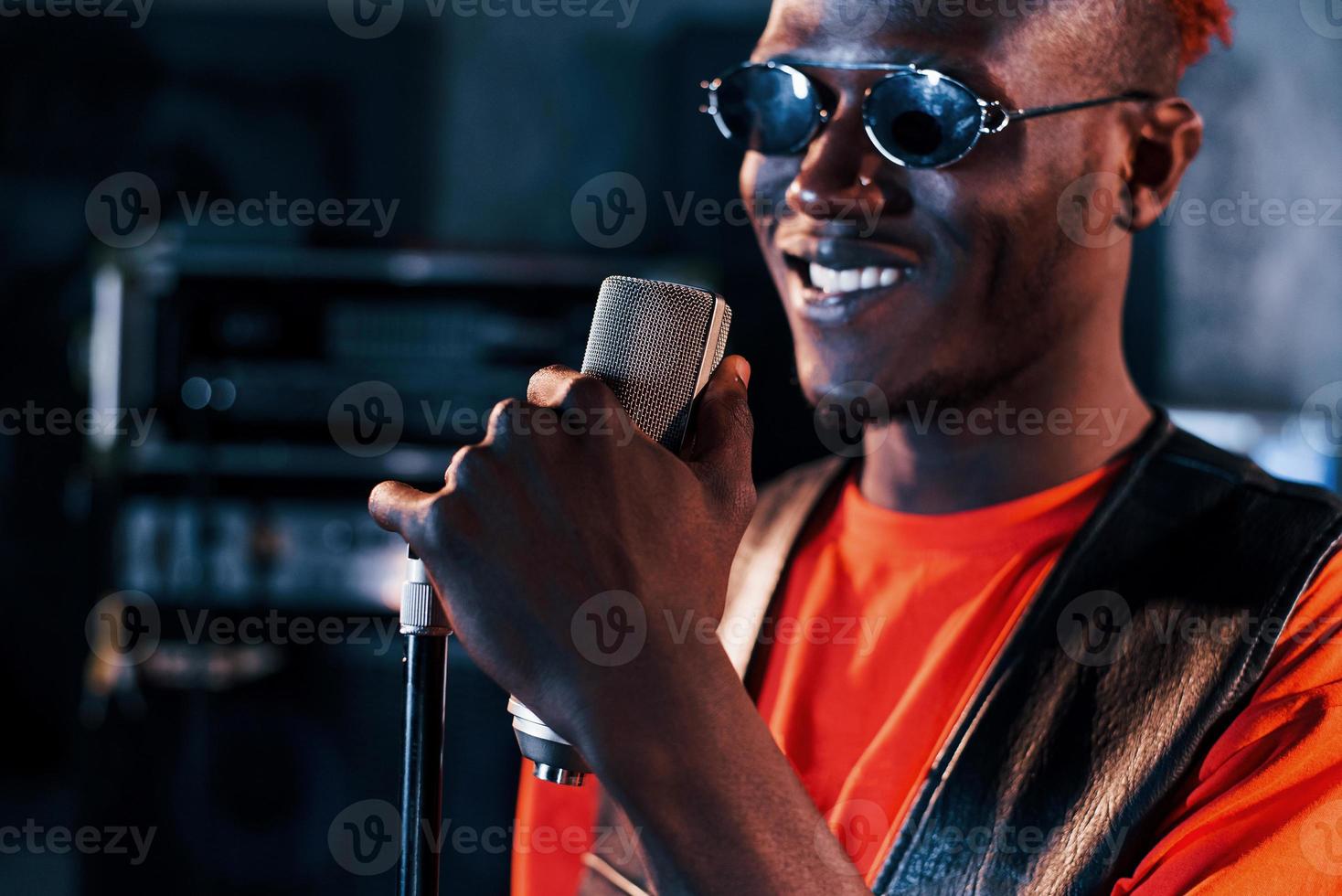 Having vocal practice. Young african american performer rehearsing in a recording studio photo