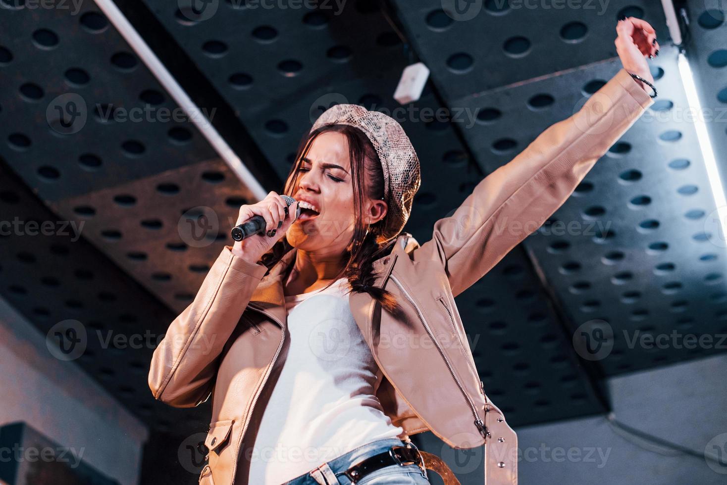 Young beautiful female performer rehearsing in a recording studio photo