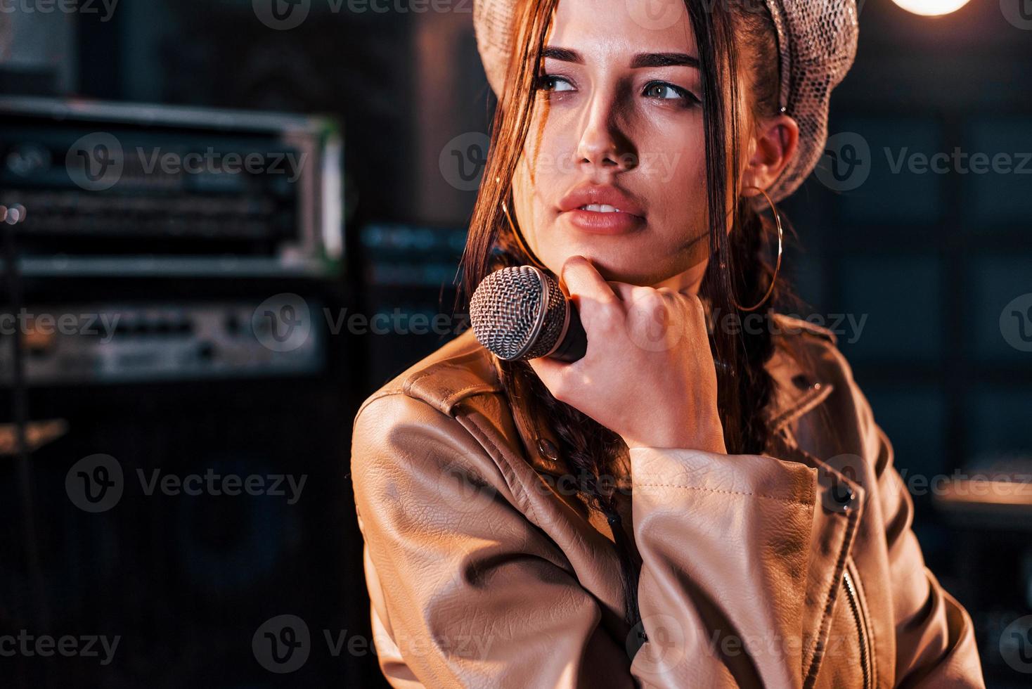 Young beautiful female performer rehearsing in a recording studio photo