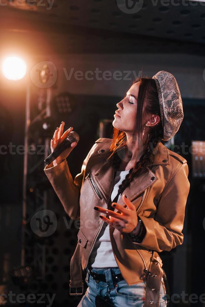 Young beautiful female singer rehearsing in a recording studio photo