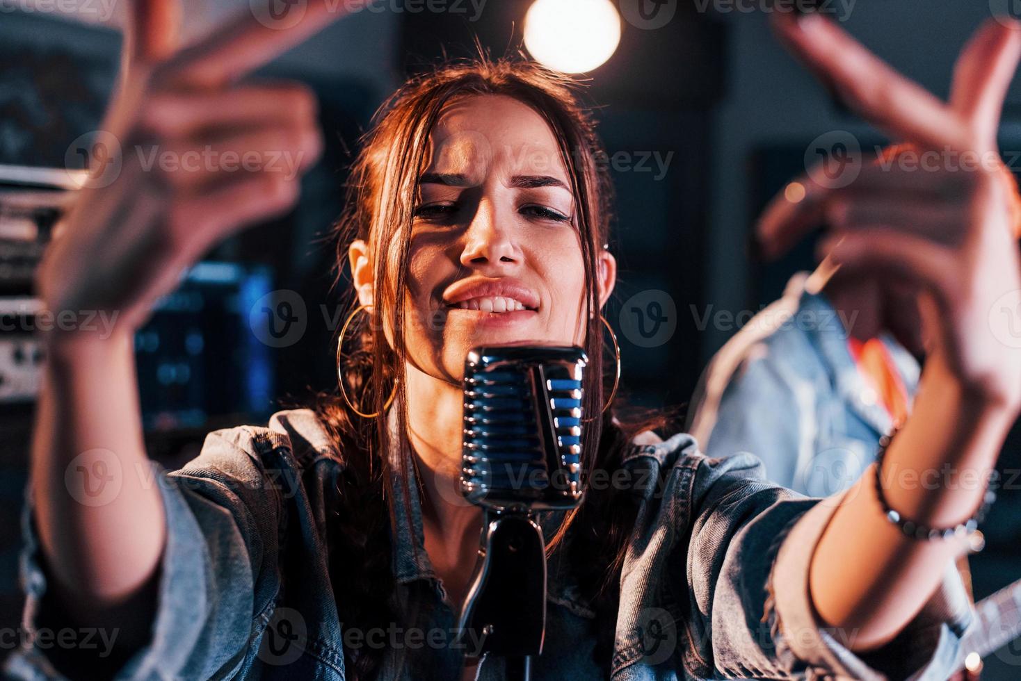 Guy plays guitar, girl sings. African american man with white girl rehearsing in the studio together photo