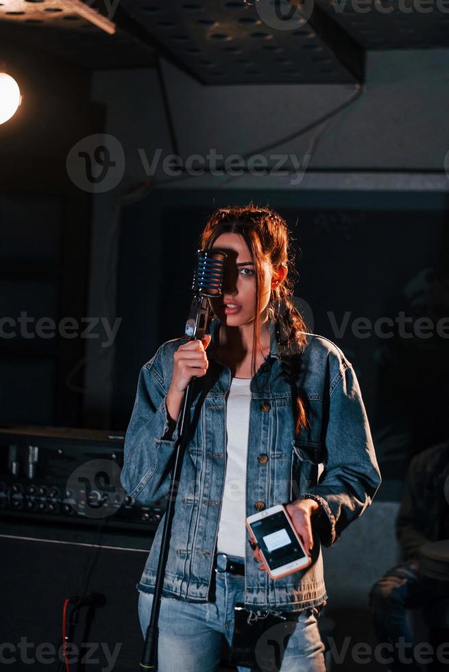 Young beautiful female performer rehearsing in a recording studio photo